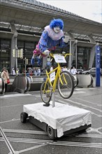 Carnival reveller flying hero on bicycle