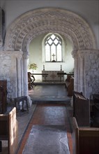 Elaborately decorated stone 12th century Norman chancel arch inside the historic village parish
