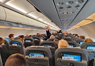Passengers in the interior of an aircraft during the safety demonstration by the flight attendants