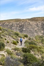 Man cycling on path between Las Negras and Cala de San Pedro, Cabo de Gata Natural Park, Almeria,