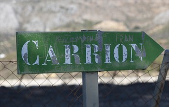 Road sign for small hamlet of Carrion, near Periana, Axarquia, Andalusia, Spain at base of