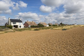 On the left is Ronina, former MOD house redesigned by Casswell Bank architects on beach at Shingle