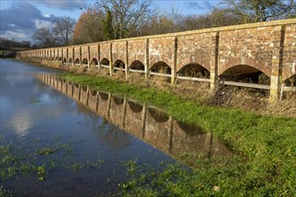 Arches of Maud Heath's causeway reflected by flood water, Kellaways, Wiltshire, England, UK