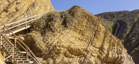Folded sedimentary rock strata dipping downwards in cliff at Praia dos Alteirinhos, Zambujeira do