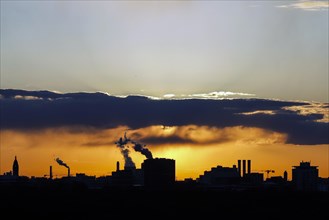 Plumes of smoke from the chimneys of a combined heat and power plant and a waste-to-energy plant at