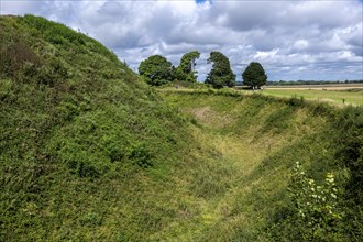 Deep defensive ditch and rampart at Old Sarum castle, Salisbury, Wiltshire, England, UK