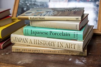 Books on Japanese art an ceramics on display in house clearance auction sale room, UK
