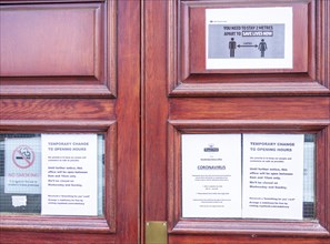 Coronavirus Covid-19 social distancing notices on door of Royal Mail delivery office, Woodbridge,