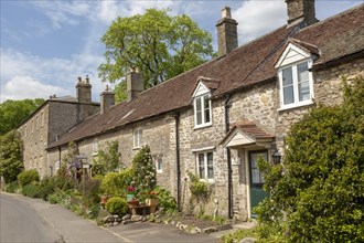 Row of attractive old stone cottages in village of Mells, Somerset, England, UK