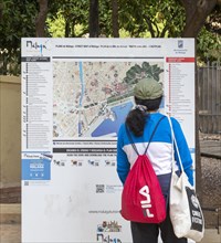 Person looking at plan map of city centre of Malaga, Andalusia, Spain showing locations of main
