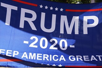 Convinced Trump supporters in Germany hold up a banner with the campaign slogan Trump 2020 - keep
