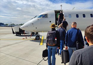 Passengers with hand luggage boarding a small aircraft on the tarmac, Duesseldorf Airport, North