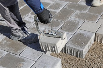 Workers lay paving stones