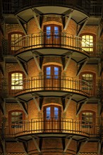 Close-up of three illuminated balconies in Hamburg's Speicherstadt warehouse district