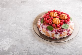 Homemade jelly cake with milk, cookies and raspberry on a gray concrete background. side view, copy