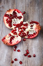 Opened ripe garnet with seeds on a rustic wooden background