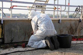 Professional asbestos removal by workers in protective suits