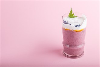 Smoothie with honeysuckle, linen and chia in a glass on pink pastel background. side view, close