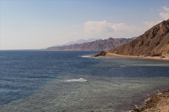 The coastline of the Red Sea with small resorts and the mountains in the background. Coral reef