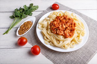 Fettuccine bolognese pasta with minced meat on white wooden background. top view, close up