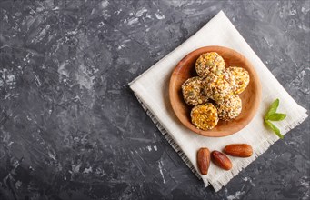 Energy ball cakes with dried apricots, sesame, linen, walnuts and dates with green mint leaves in a