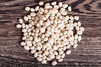 Pile of white beans isolated on a gray wooden background. Top view