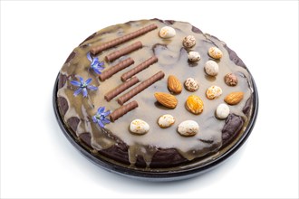 Homemade chocolate brownie cake with caramel cream and almonds isolated on a white background. Side