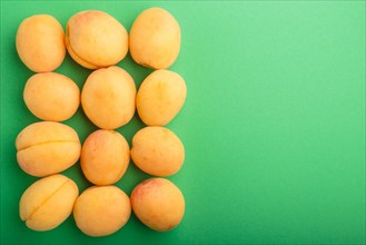 Apricots on a green pastel background, top view, flat lay, copy space