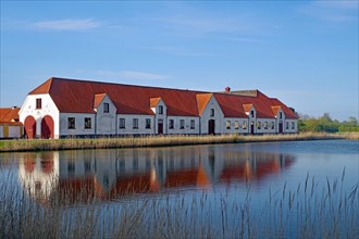 Large houses and the teahouse at Valdemars Slot are reflected in the calm water, Valdemars Slot,
