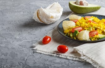 Fried pomelo with tomatoes and avocado on gray concrete background. side view, close up, copy