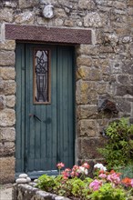 Old wooden door in a typical stone house, granite stone house, Ile de Brehat, Departement