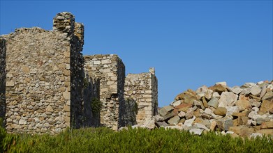 Remnants of ancient walls towering against a clear blue sky, Methoni sea fortress, Peloponnese,