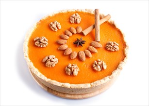 Traditional american sweet pumpkin pie decorated with nuts, isolated on white background. close up