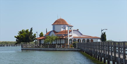 Small church with tiled roof on the water's edge with connection via a bridge, Monastery of St