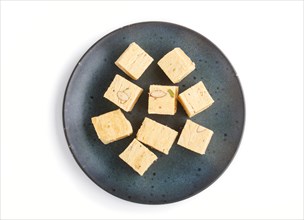 Traditional indian candy soan papdi in blue ceramic plate isolated on a white background. top view,