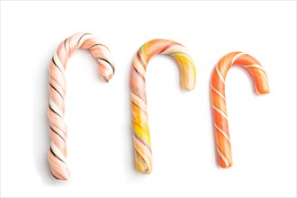 Three christmas cane candies isolated on white background. close up, top view, flat lay