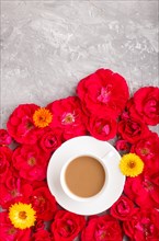 Red rose flowers and a cup of coffee on a gray concrete background. Morninig, spring, fashion