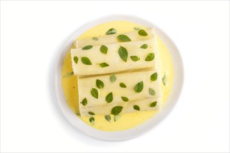 Cannelloni pasta with egg sauce, cream cheese and oregano leaves isolated on white background. top