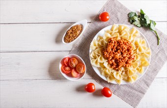 Farfalle bolognese pasta with minced meat on white wooden background. top view, copy space