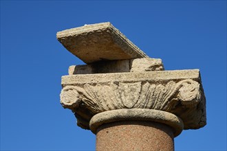 Close-up of an ancient column capital with detailed relief against a clear sky, sea fortress