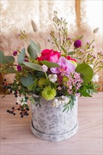 Composition of autumn flowers in a hat box on a wooden background. floristic arrangement