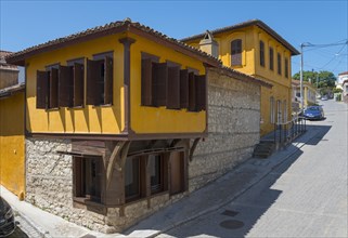 Two-storey traditional house with yellow facade and open shutters, Soufli, Eastern Macedonia and