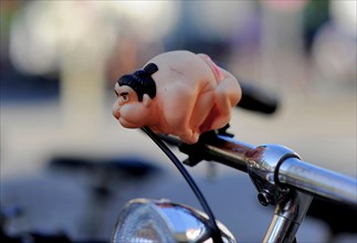 A sumo wrestler attached to the handlebars of a bicycle as a bicycle horn or bell
