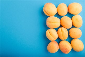 Apricots on a blue pastel background, top view, flat lay, copy space