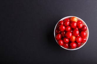 Fresh red sweet cherry in white bowl on black background. top view, flat lay, copy space