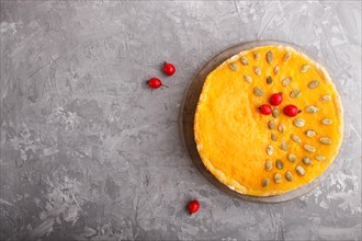 Traditional american sweet pumpkin pie decorated with hawthorn red berries and pumpkin seeds on a