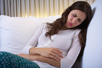 Woman on couch with menstrual cramps clutching stomach in pain. KI generiert, generiert AI