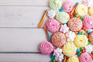 Mixed multicolored candies on white wooden background. copy space, top view, flat lay