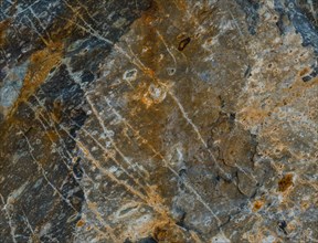 Closeup of granite boulder surface with visible marks created when quarried from ground in South