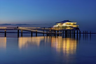Blue hour at the illuminated Mikado house on the beach of Timmendorf on the Baltic Sea as a long